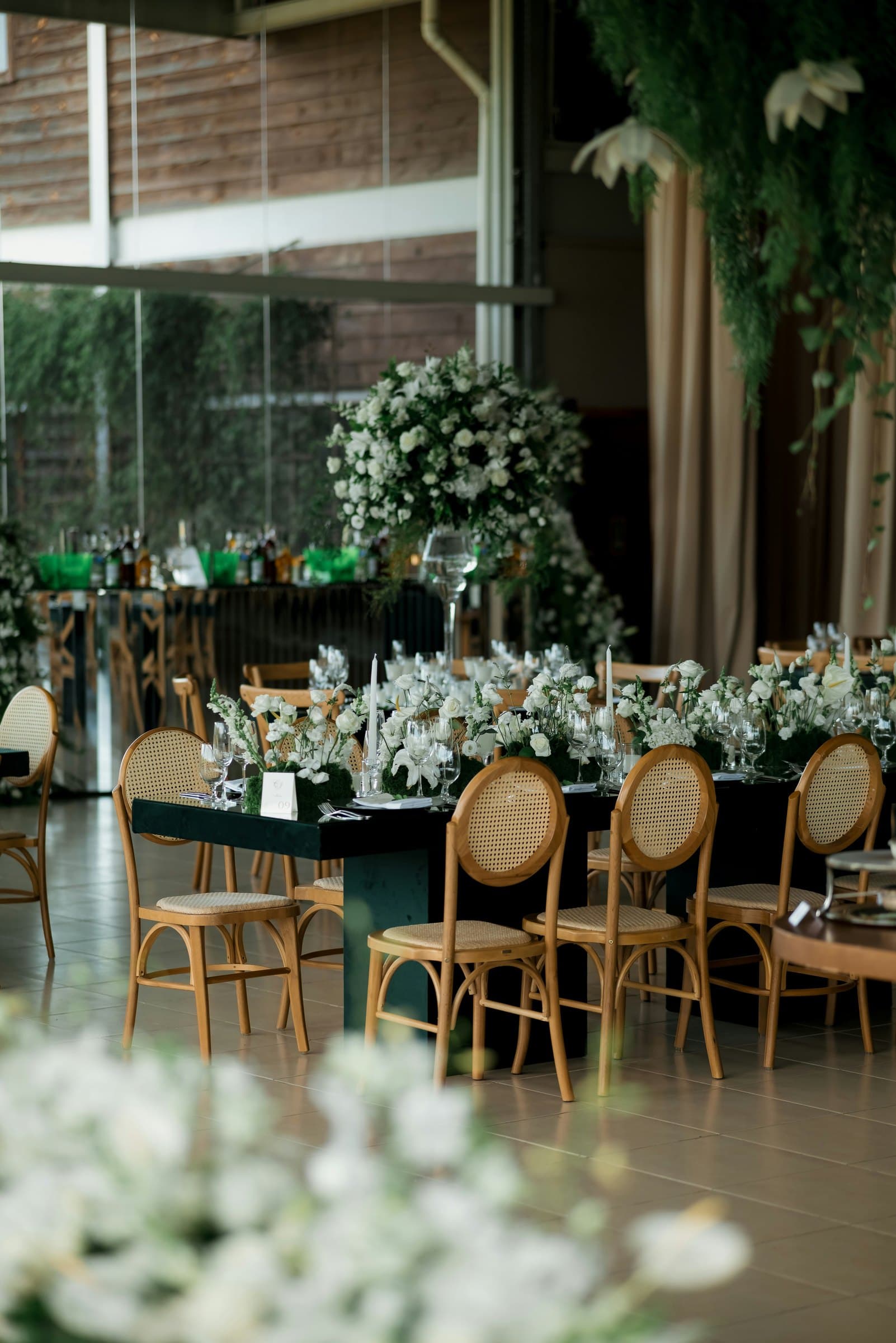 Wedding reception tables with floral centerpieces and gold-framed chairs
