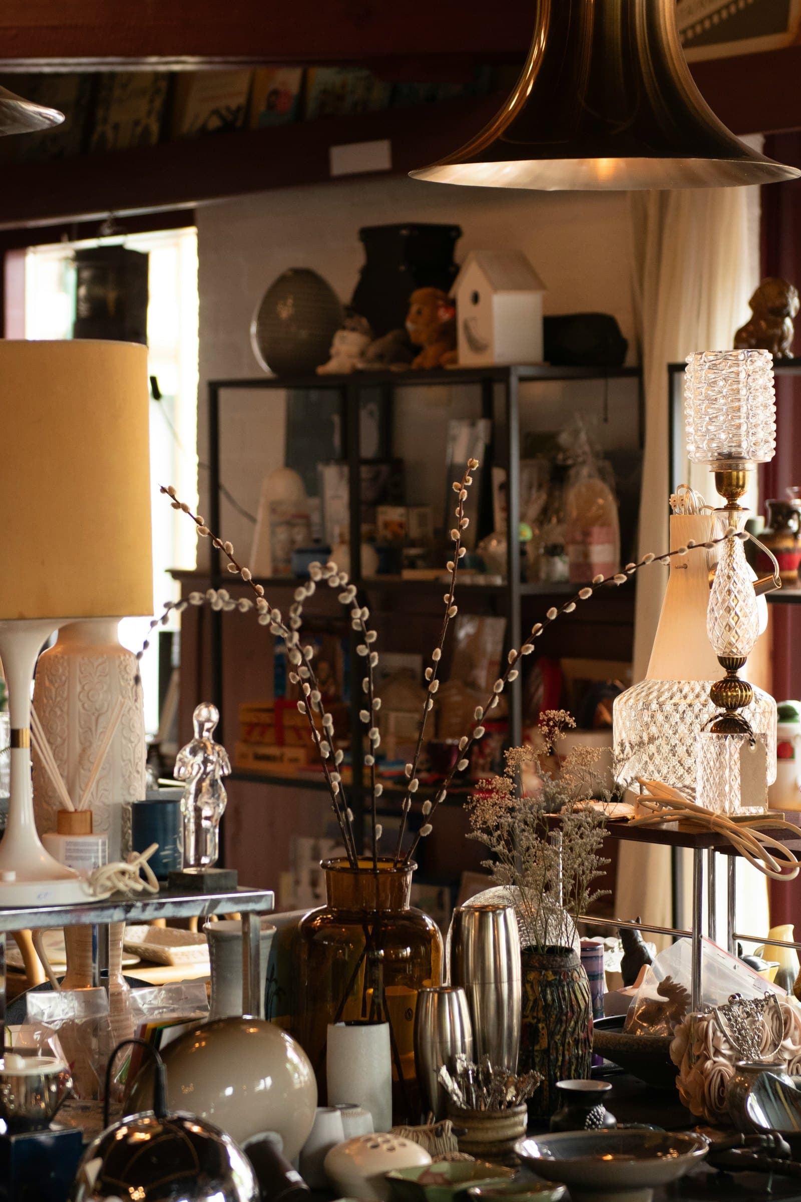 Vintage shop filled with decorative vessels, lamps, and candlesticks